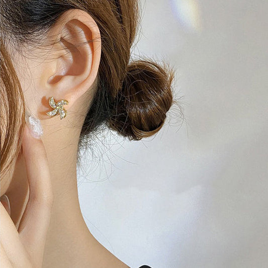 Earrings shaped like a small rotating windmill